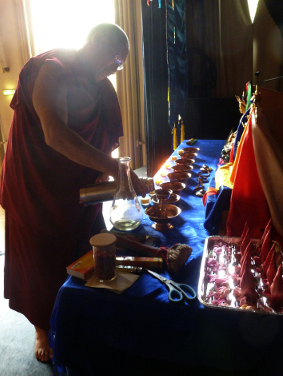 Lama Sangye Monlam filling
    water bowls on the altar, Graz 2012